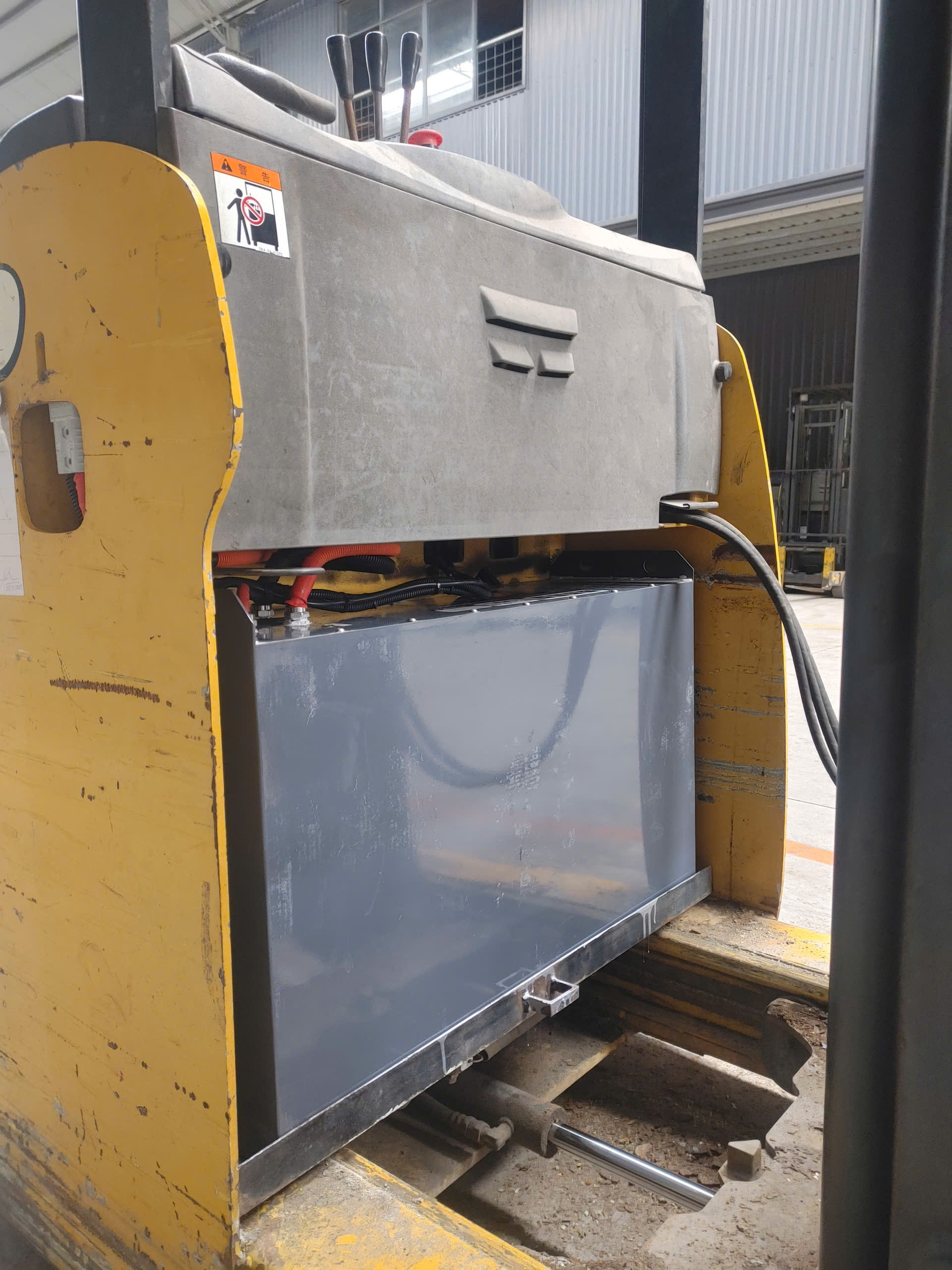 Bộ pin vỏ màu bạc đặt trong khoang xe nâng Komatsu