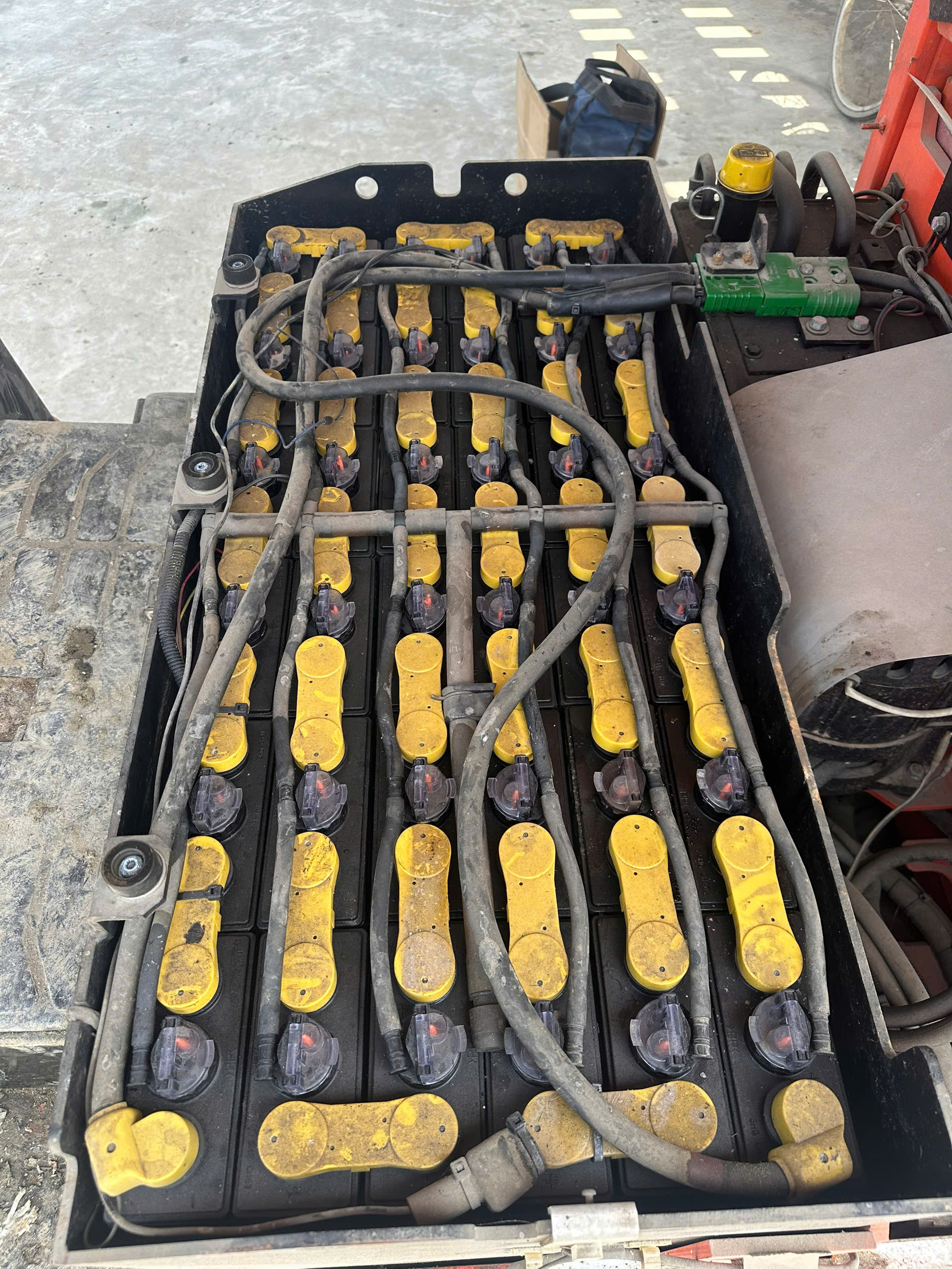 Cụm ắc quy chì với các nắp vàng trên xe nâng trước khi thay pin lithium